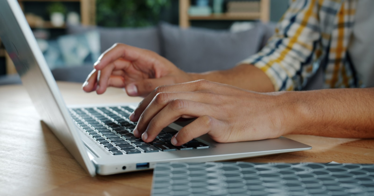 Copywriter al lavoro su un laptop, mani sulla tastiera, tema del codice ateco copywriter forfettario