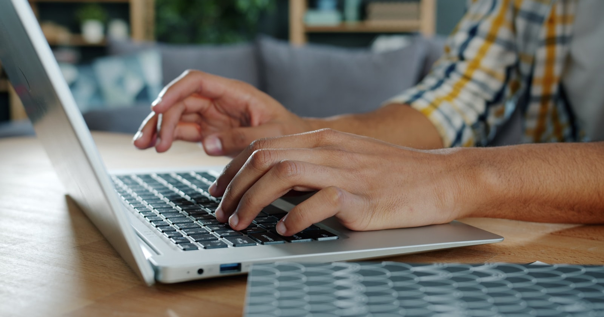 Copywriter al lavoro su un laptop, mani sulla tastiera, tema del codice ateco copywriter forfettario