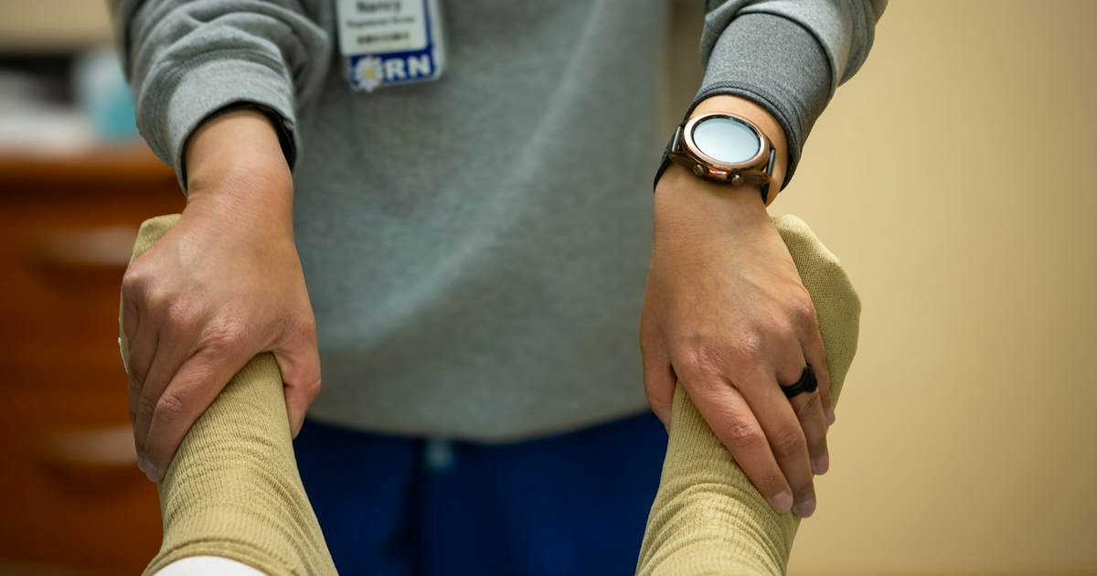 Professionista sanitario che tratta le gambe di un paziente in uno studio clinico, tema del codice ateco fisioterapista forfettario