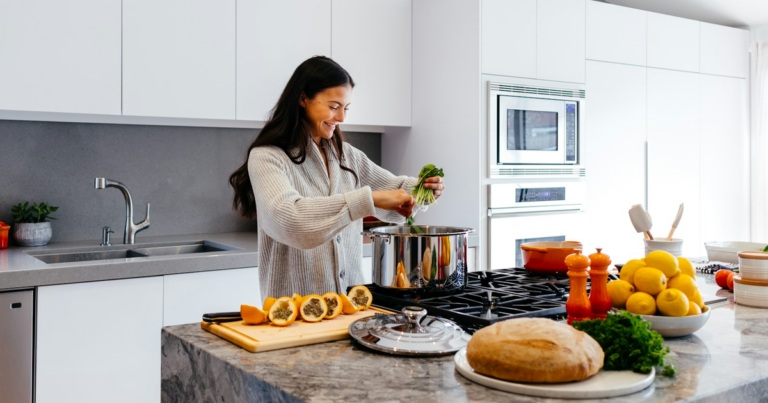Donna che prepara un piatto sano in cucina con frutta e verdura fresca, tema del codice ateco nutrizionista forfettario
