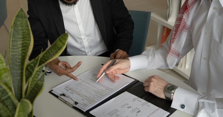 Due professionisti che esaminano documenti a un tavolo, riferimento alle cause di esclusione regime forfettario